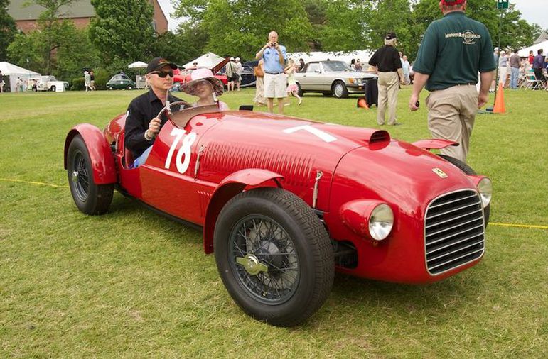 Jim Glickenhaus sitting in red 1947 Ferrari 159 Spyder Corsa