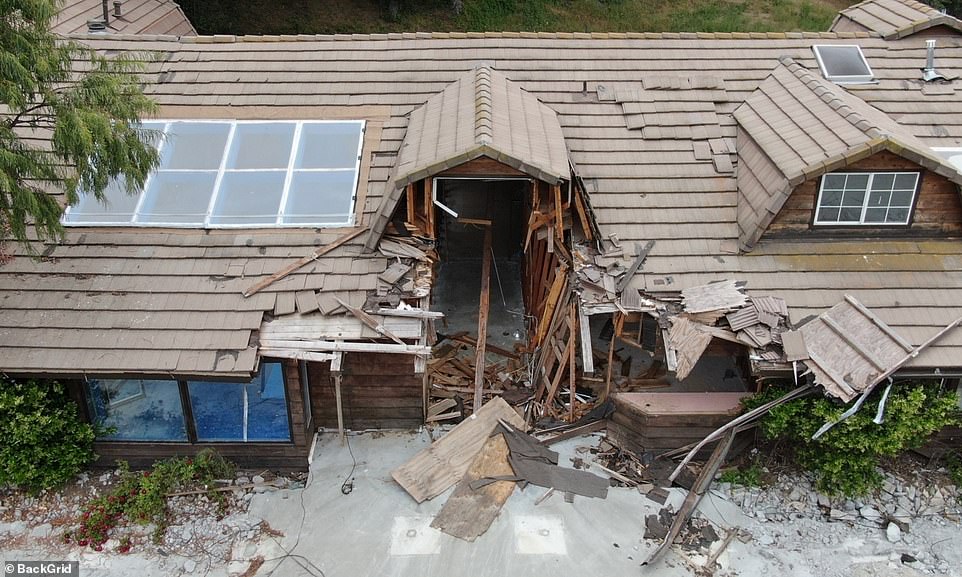 The area surrounding the main home on the property is unkept with dry patches of grass as well as piles of dirt or sand