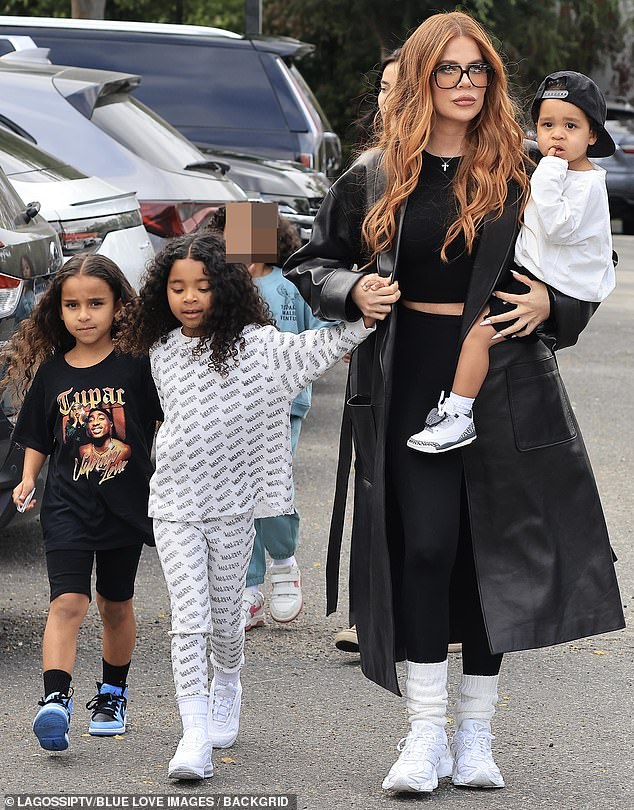 The Kardashians star carried her son Tatum, 21 months, while holding handing hands with six-year-old daughter True , whom she shares with ex Tristan Thompson