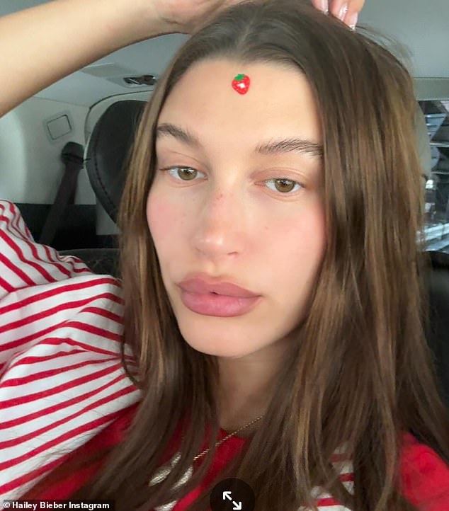 In a new series of snaps, Hailey Bieber posted a picture of herself wearing a strawberry sticker on her forehead - which Kendall Jenner believes may be a part of her latest Rhode Skin drop