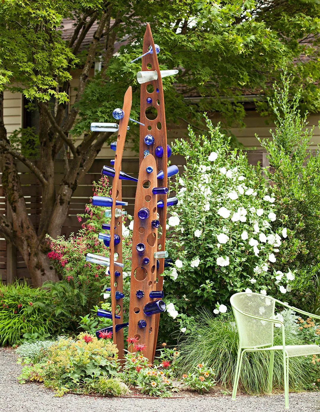 sustainable garden design blue bottles outdoor art tree