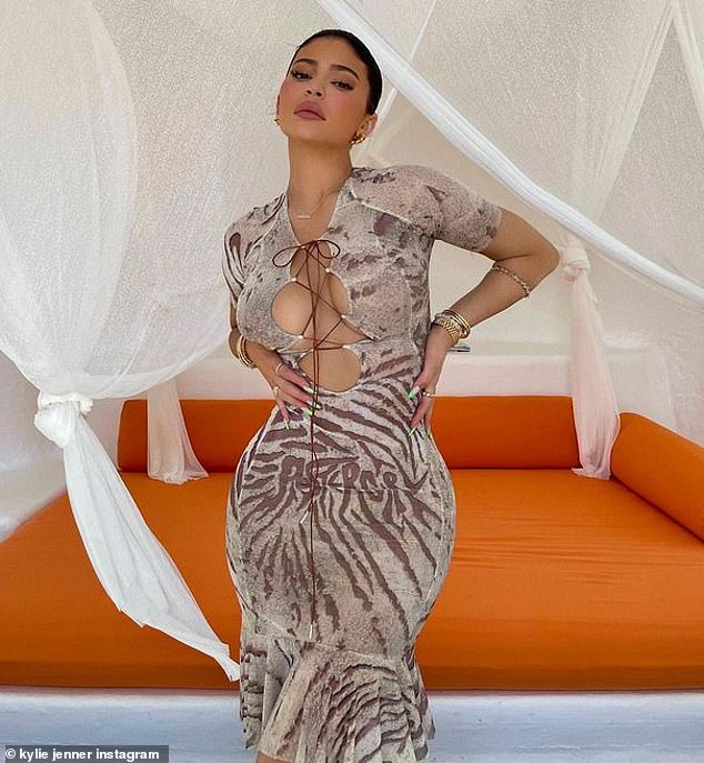 Bombshell: Kylie Jenner commanded attention in a racy animal-print dress, which clung to her every curve as she posed in front of a bright orange daybed in Jalisco, Mexico