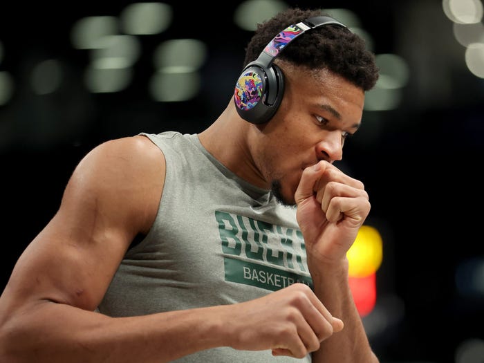 Giannis Antetokounmpo warms up wearing headphones from his sponsor, JBL.